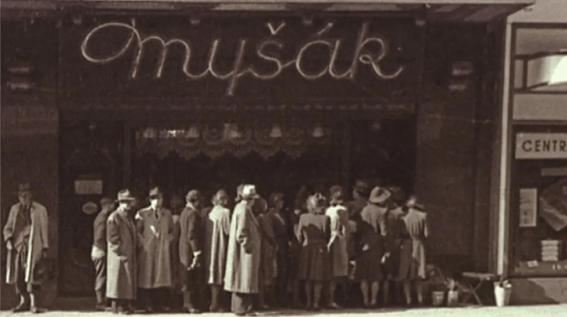 Historická fotografie fronty zákazníků před cukrárnou Myšák.